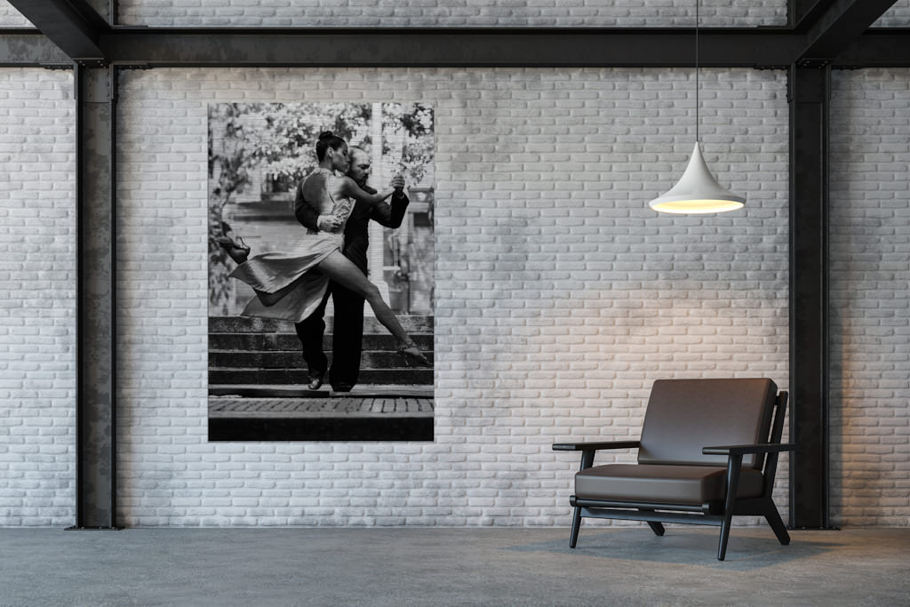 Ein schwarz-weißes Fotokunstwerk hängt in einer Loft. Abgebildet ist ein Paar, dass Tango tanzt.