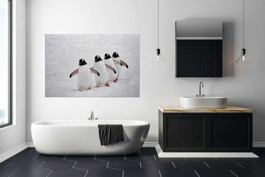 Ein Fotokunstwerk, im Badezimmer einer Loft, mit vier hintereinander laufenden Pinguinen im Schnee.